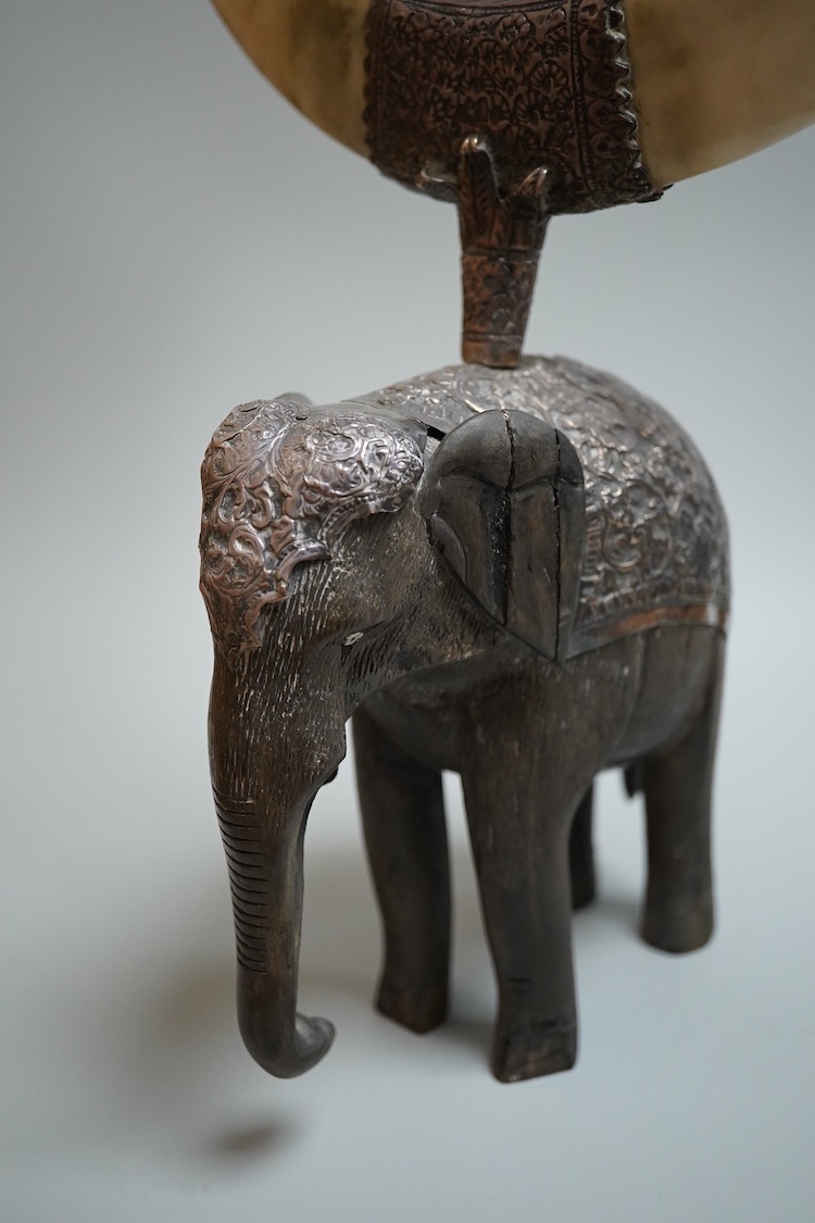 A late 19th century Indian white metal mounted carved hardwood model of an elephant, surmounted by a pair of removeable warthog tusks, overall height 40cm